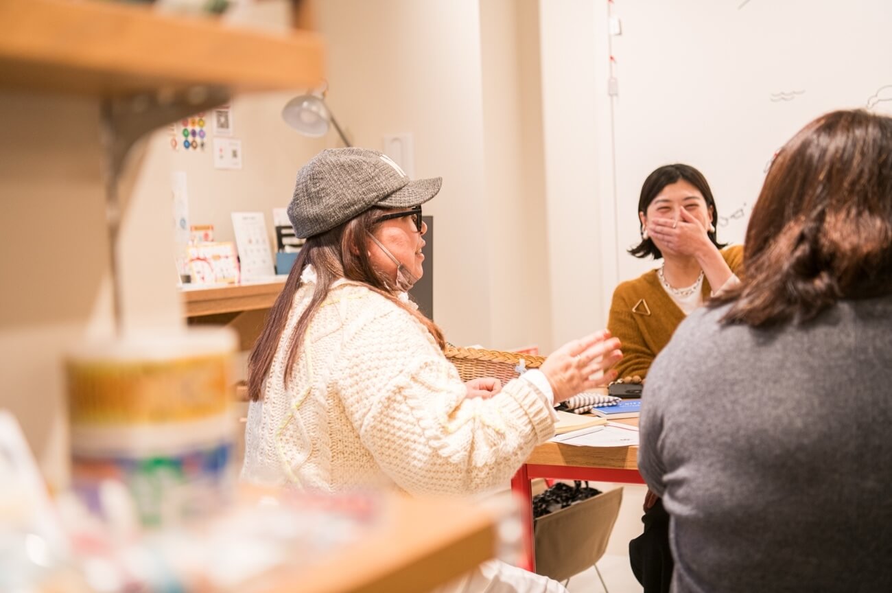 写真：イベントにて参加者がテーブルを囲み、笑いを交えながら話し合う様子