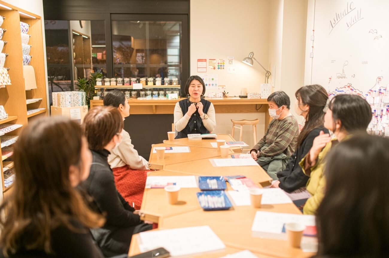 写真：イベントにて参加者がテーブルを囲み説明を聞く様子