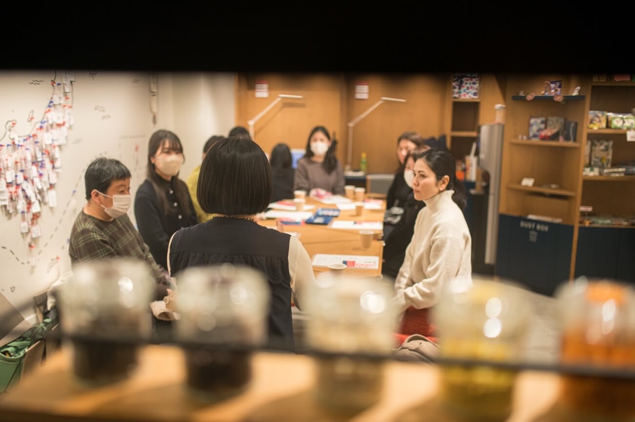 写真：イベントにて参加者がテーブルを囲み説明を聞く様子