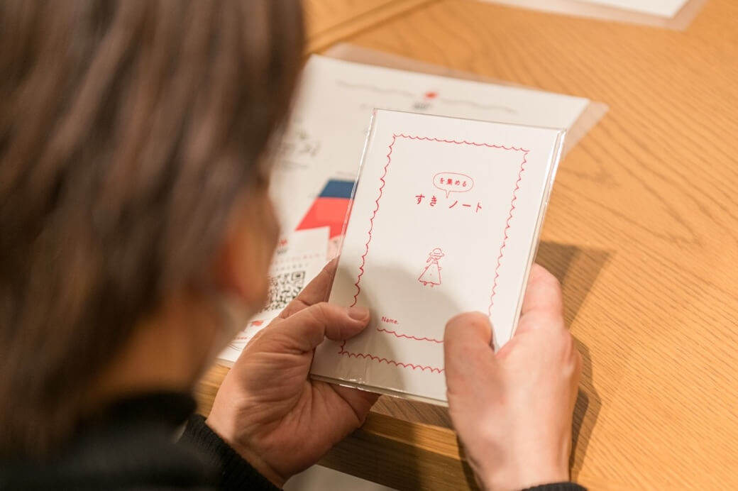 写真：“ギフトすきノート”を手に取る様子